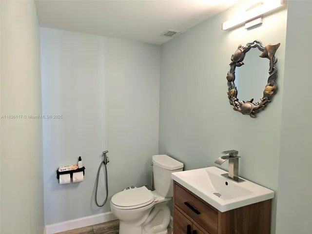 a bathroom with a sink mirror and toilet
