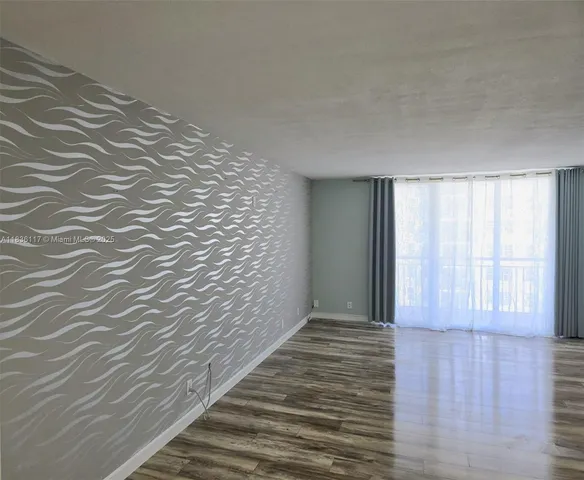 a view of a room with wooden floor and brick walls