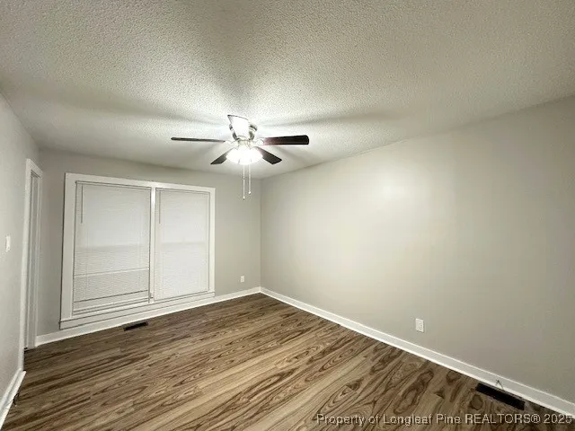 a large white kitchen with wooden floor