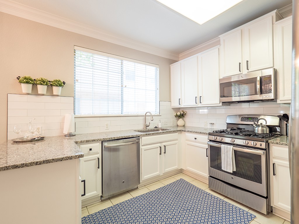 8518 Cahill Drive, Unit 47 Austin, TX 78729 - Photo 11 of 28 a kitchen with stainless steel appliances granite countertop a stove a sink and a microwave