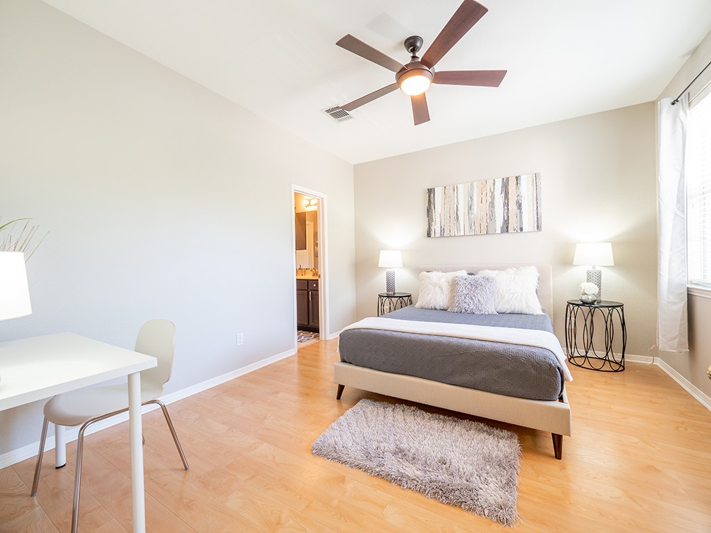 8518 Cahill Drive, Unit 47 Austin, TX 78729 - Photo 20 of 28 a spacious bedroom with a bed a table and chair