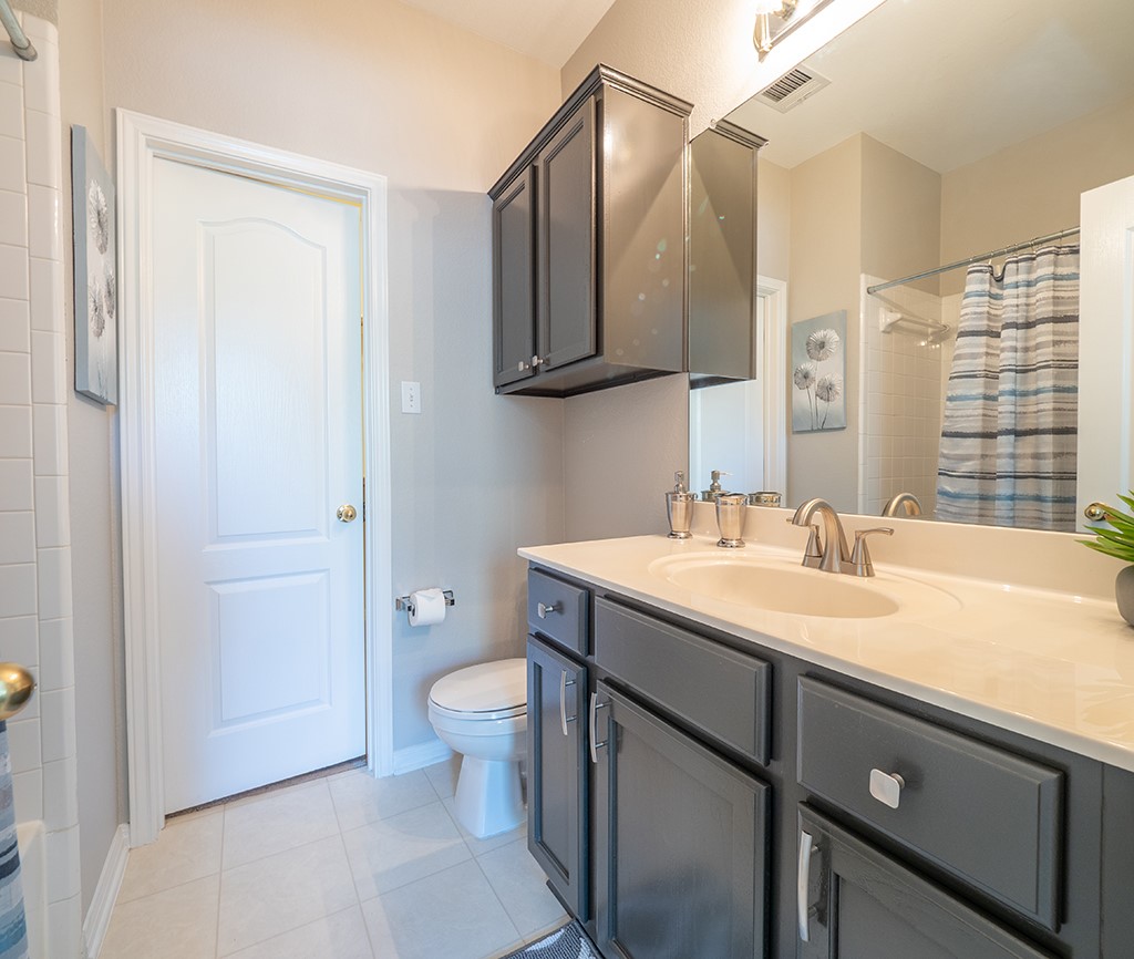 8518 Cahill Drive, Unit 47 Austin, TX 78729 - Photo 23 of 28 a bathroom with a granite countertop sink toilet and mirror