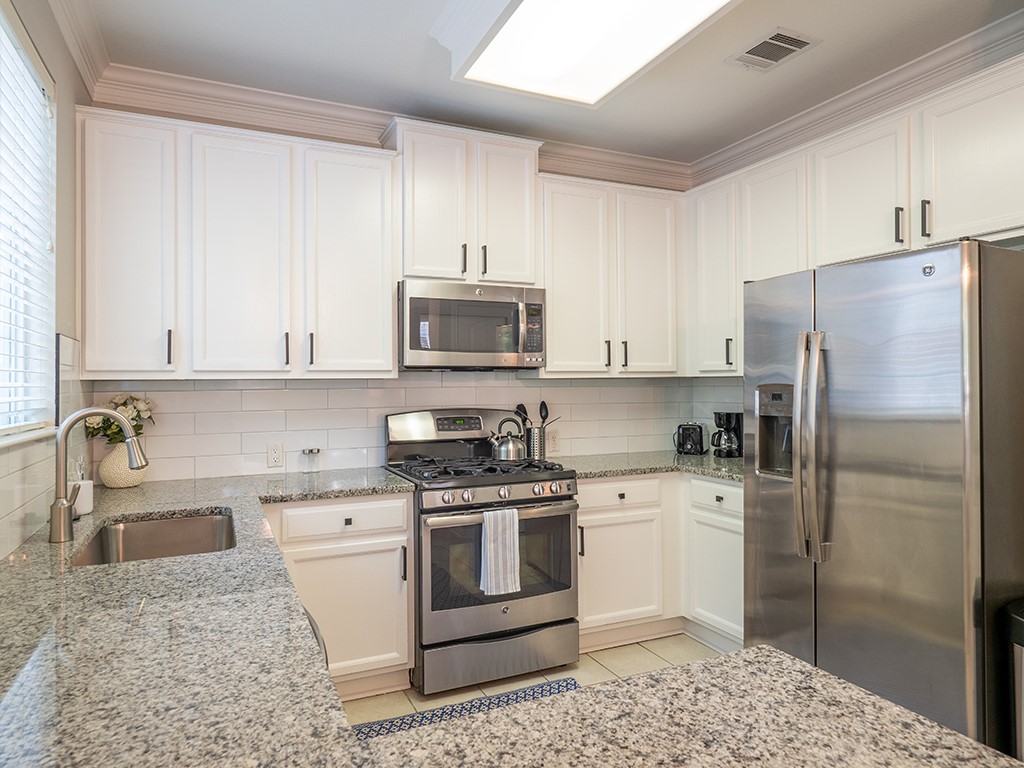 8518 Cahill Drive, Unit 47 Austin, TX 78729 - Photo 10 of 28 a kitchen with a stove a refrigerator and a sink