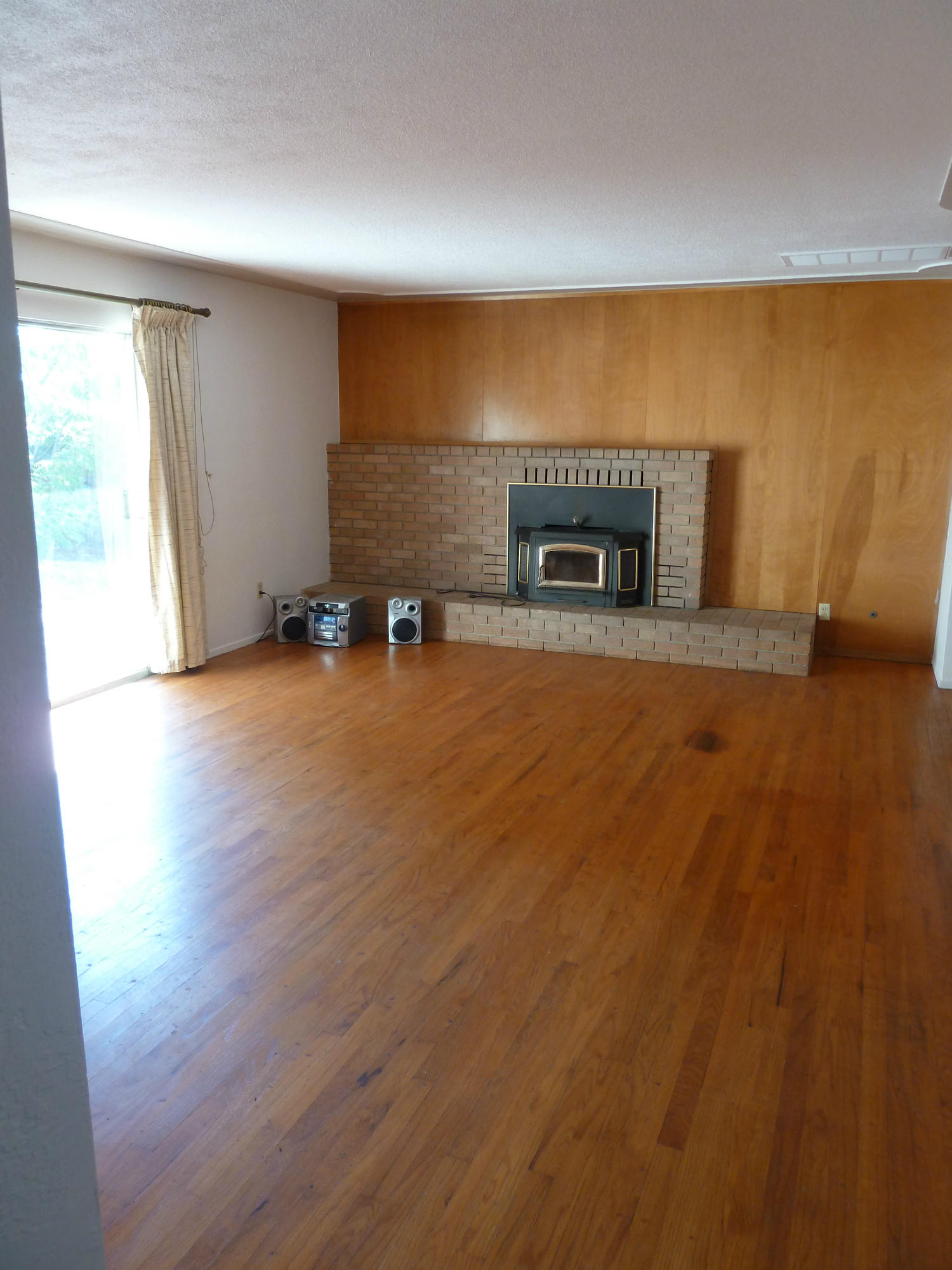 2755 Irwin Road Redding, CA 96002 - Photo 13 of 35 an empty room with wooden floor and fireplace
