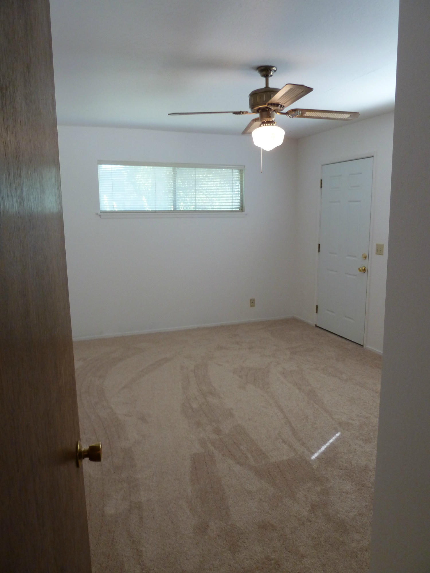 2755 Irwin Road Redding, CA 96002 - Photo 23 of 35 an empty room with a chandelier fan and windows