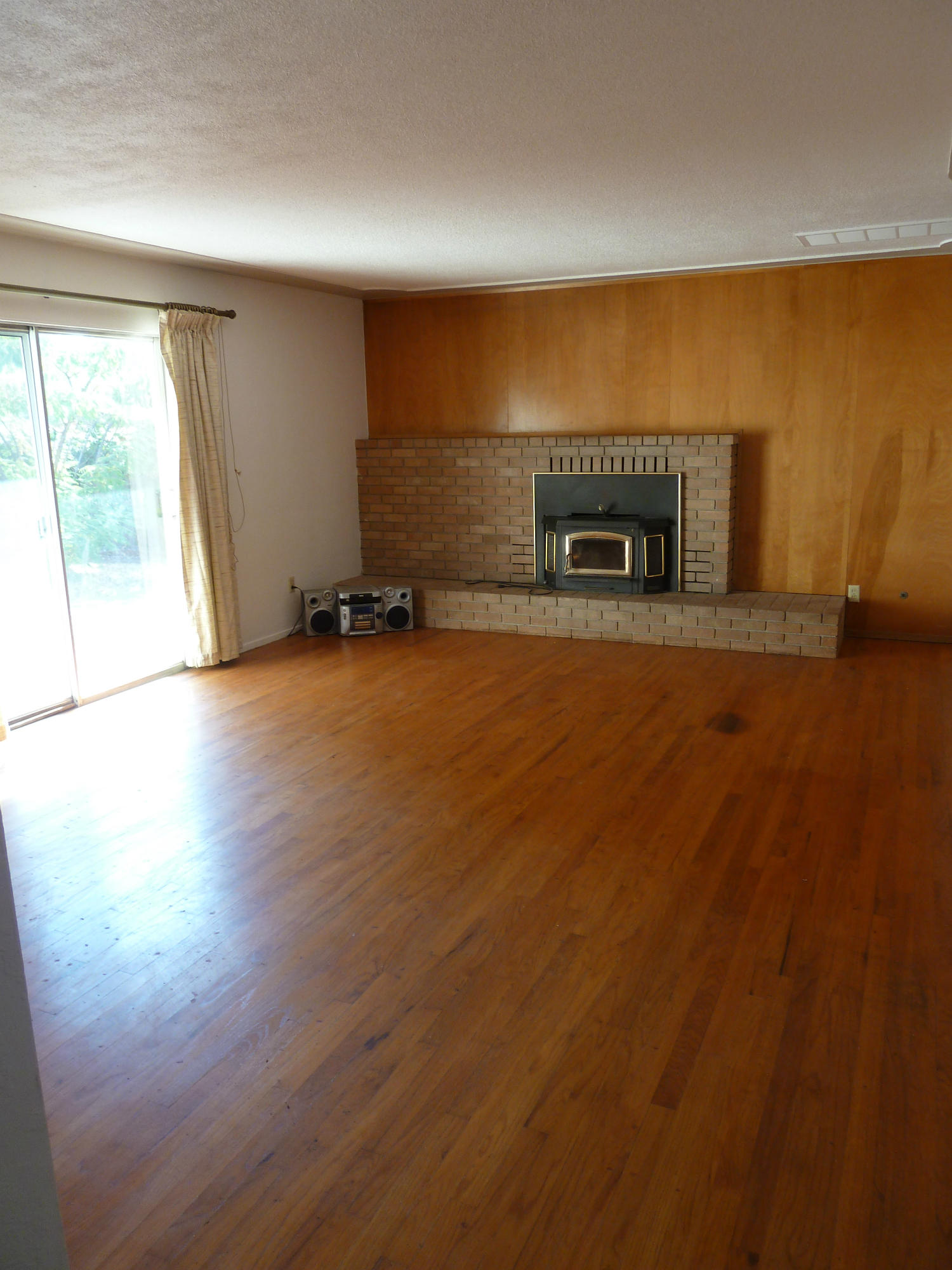 2755 Irwin Road Redding, CA 96002 - Photo 34 of 35 a view of empty room with wooden floor and fireplace
