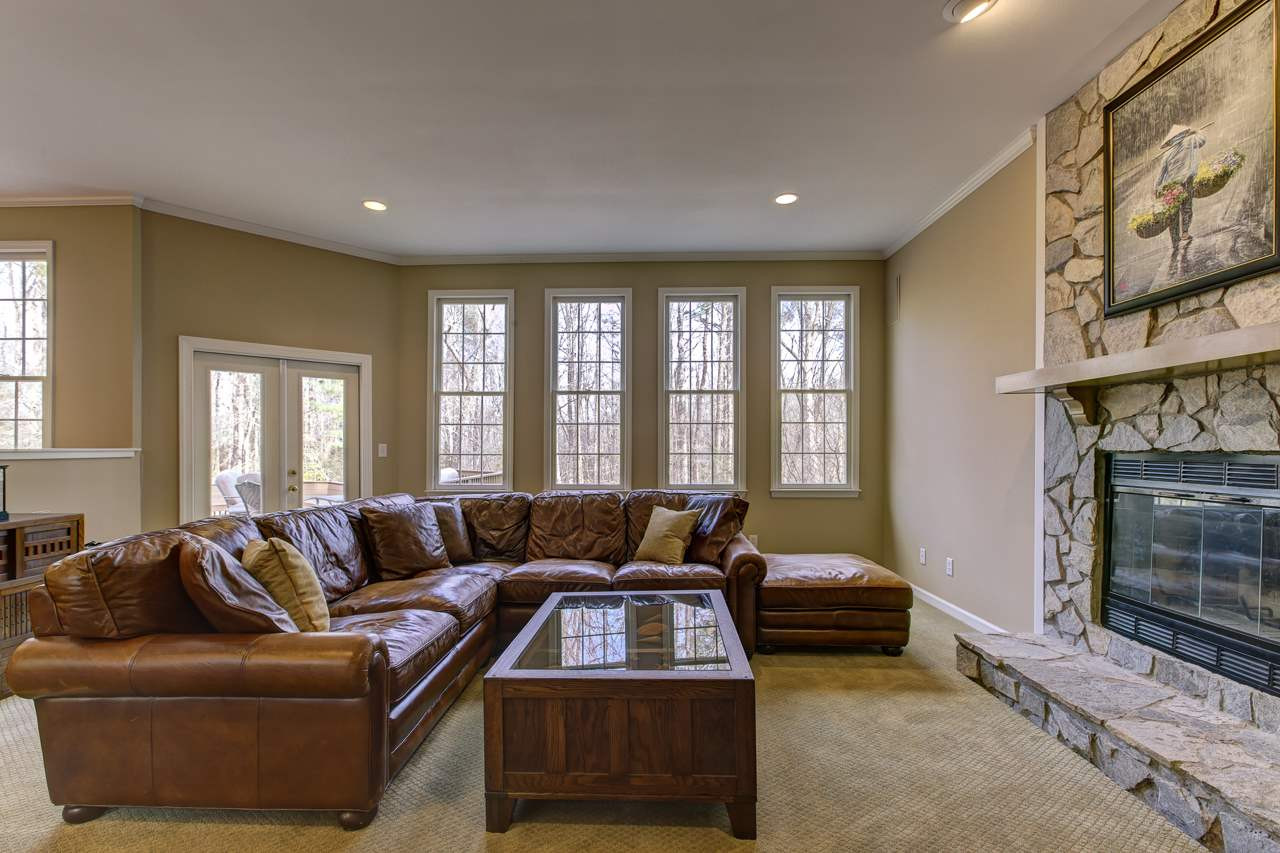 12312 Galway Drive Raleigh, NC 27613 - Photo 3 of 25 Cozy up next to the stone front fireplace in the family room or enjoy the wooded views from the wall of windows. Family Room
