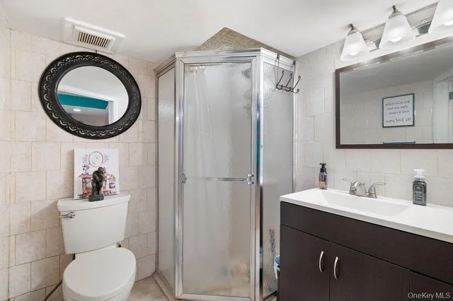 a bathroom with a toilet sink vanity and mirror