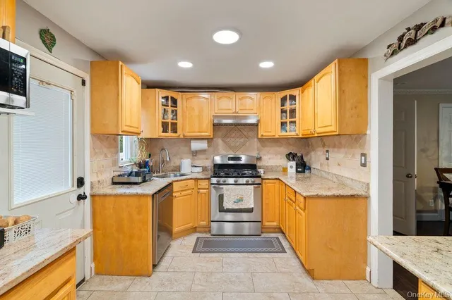 a kitchen with stainless steel appliances granite countertop a sink stove and refrigerator