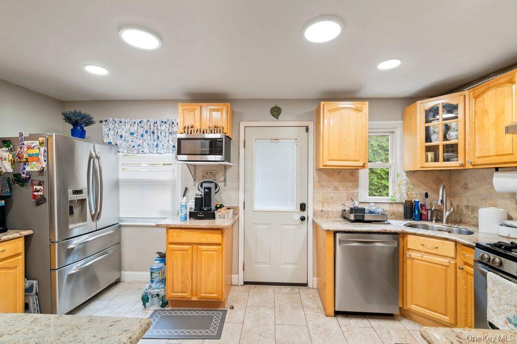 21 Jasper Street Valley Stream, NY 11580 - Photo 10 of 27 a kitchen with stainless steel appliances a refrigerator sink and cabinets