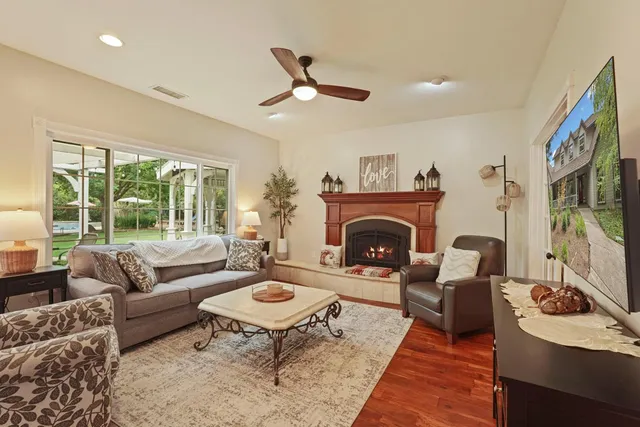 a room with wooden floor pool table and chairs