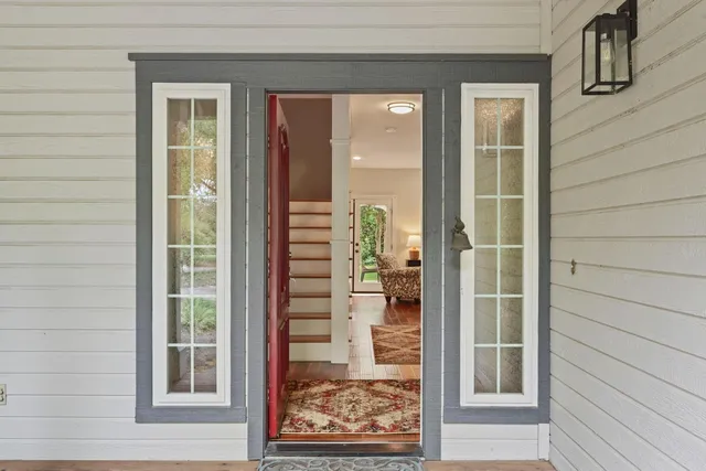 a kitchen with stainless steel appliances kitchen island granite countertop a refrigerator a sink dishwasher and white cabinets with wooden floor