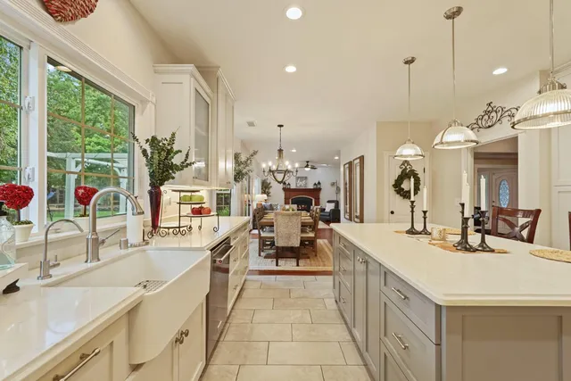 a kitchen with white cabinets a sink dishwasher and a stove with wooden floor