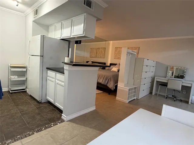 a kitchen with refrigerator and cabinets