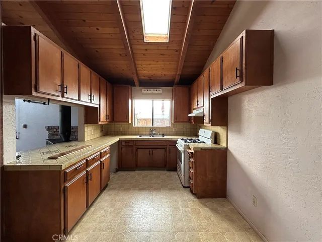 a kitchen with stainless steel appliances granite countertop a stove sink and cabinets