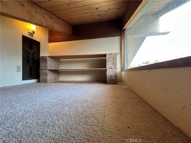 a view of an empty room with a fireplace and a window
