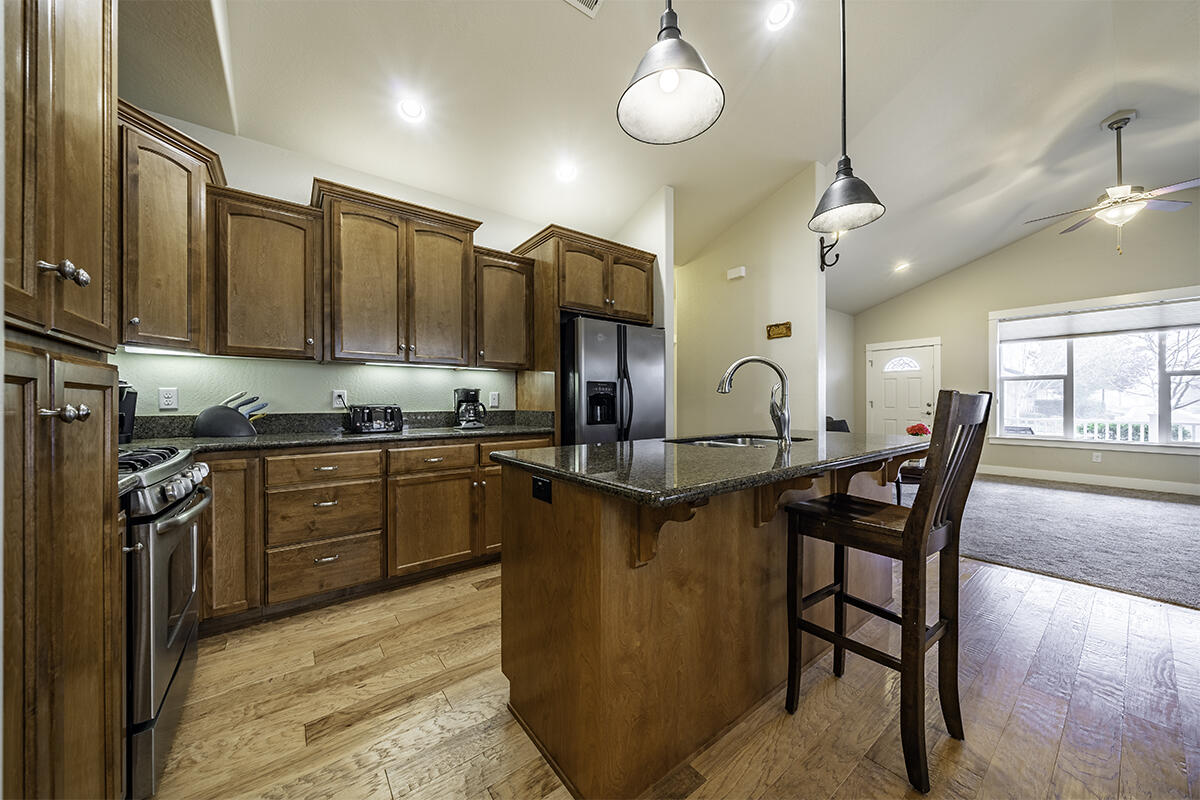 1078 North Haskell Street Central Point, OR 97502 - Photo 8 of 25 a kitchen with stainless steel appliances granite countertop a stove a sink dishwasher a dining table and chairs with wooden floor
