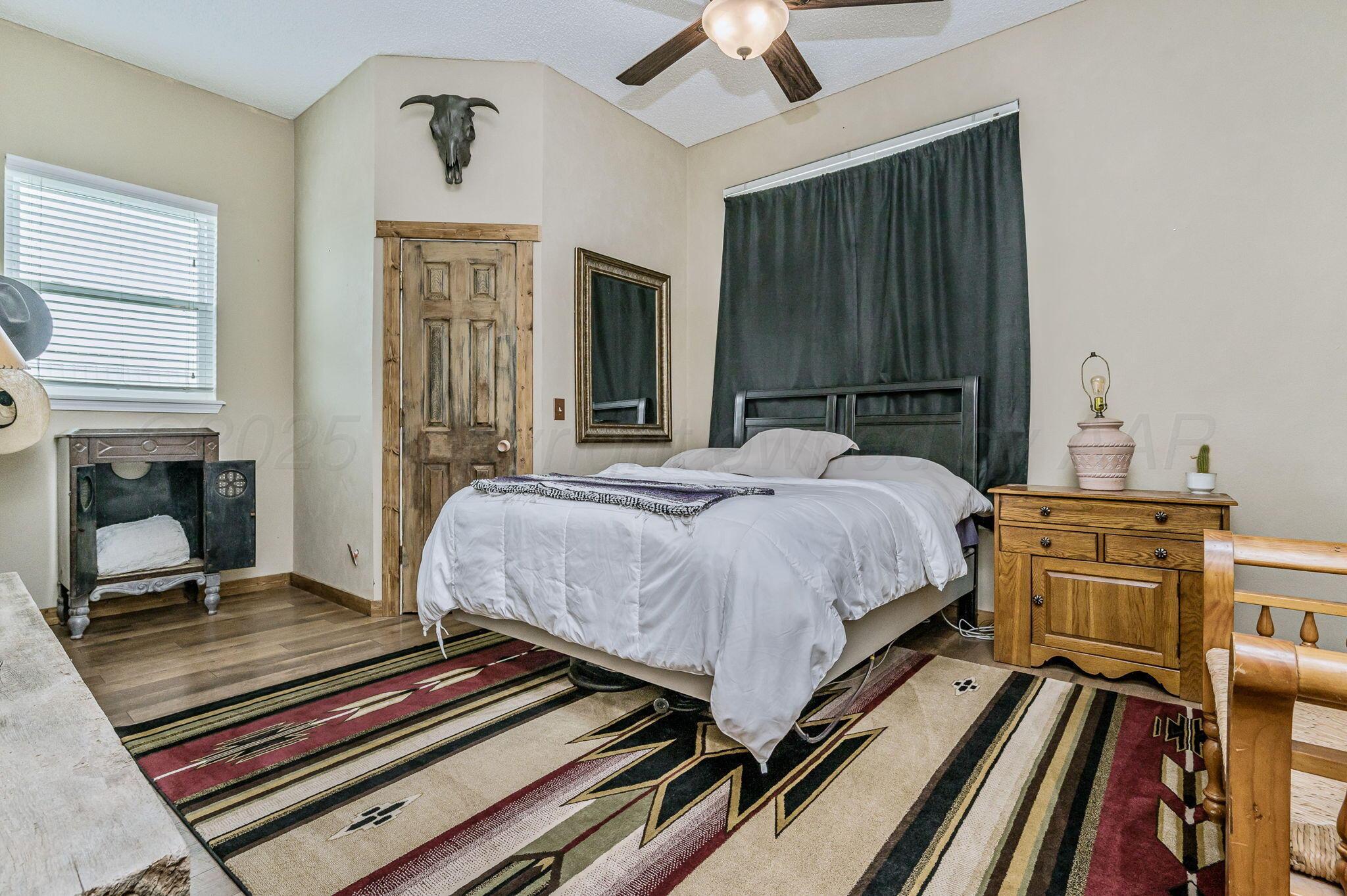 620 Lantana Road Bushland, TX 79124 - Photo 17 of 34 a bedroom with a bed and wooden floor