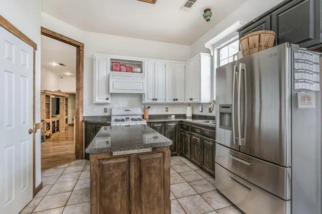 a kitchen with stainless steel appliances granite countertop a refrigerator sink and stove