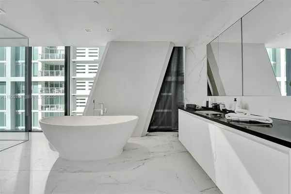 a spacious bathroom with a tub sink and mirror