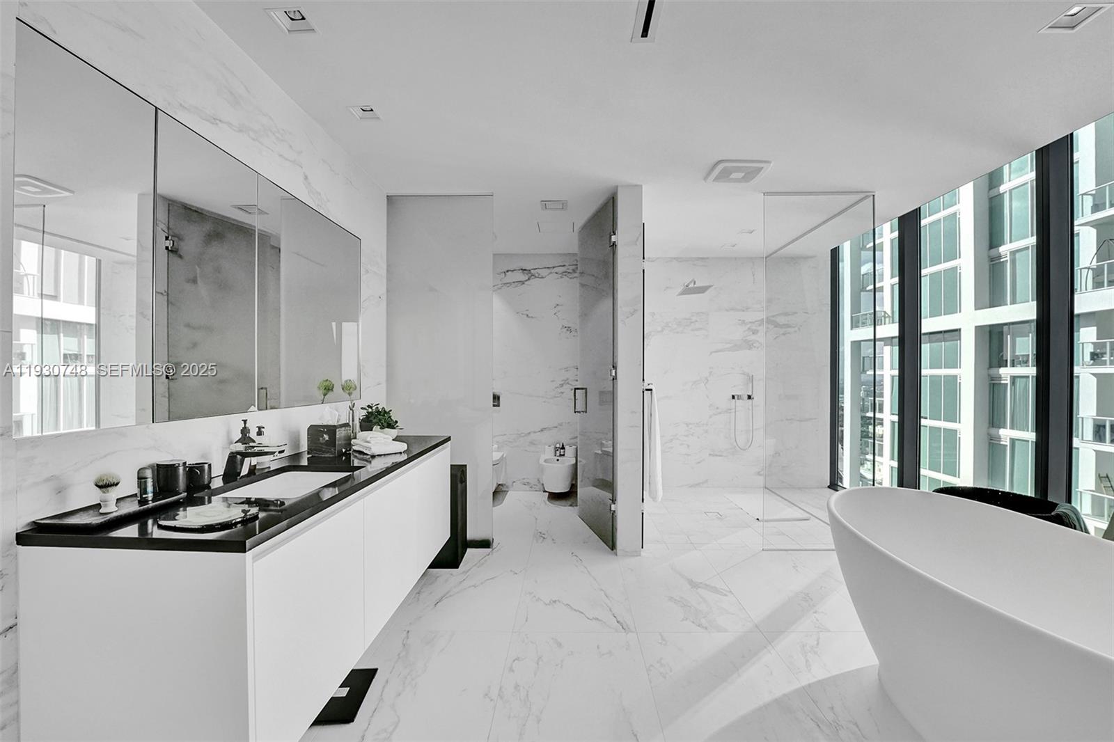 1000 Biscayne Boulevard, Unit 3902 Miami, FL 33132 - Photo 14 of 51 a spacious bathroom with a tub sink and mirror