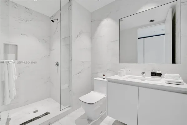 a bedroom with a bed and large windows