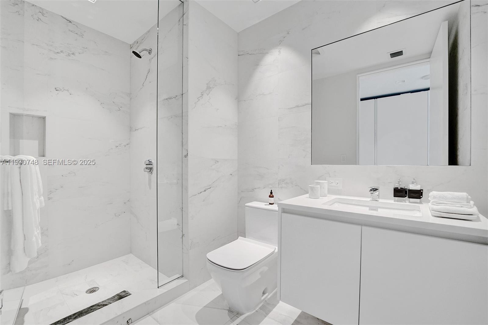 1000 Biscayne Boulevard, Unit 3902 Miami, FL 33132 - Photo 16 of 51 a bathroom with a granite countertop sink toilet a mirror and shower