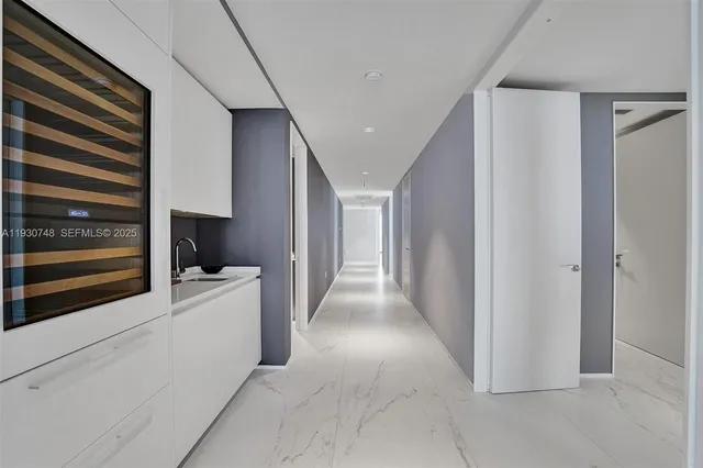 a view of a kitchen with refrigerator and white walls