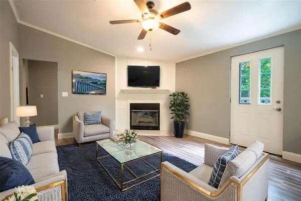 a living room with furniture a flat screen tv and a fireplace