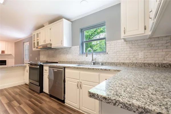 a kitchen with stainless steel appliances granite countertop a sink stove and cabinets