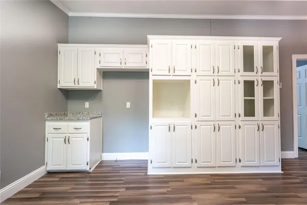 an empty room with wooden floor and cabinet