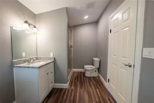a bathroom with a sink a toilet a mirror and shower