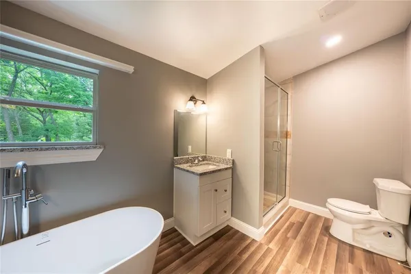 a bathroom with a sink a toilet a mirror and shower