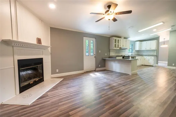 a view of a kitchen with a stove wooden cabinet and a fireplace