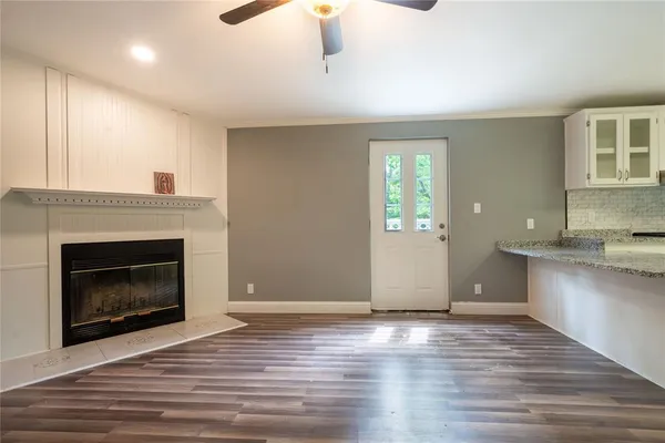 a view of an empty room with window and fire place