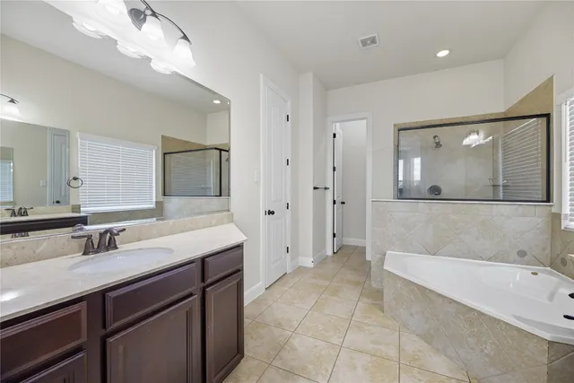 a bathroom with a bathtub sink and mirror