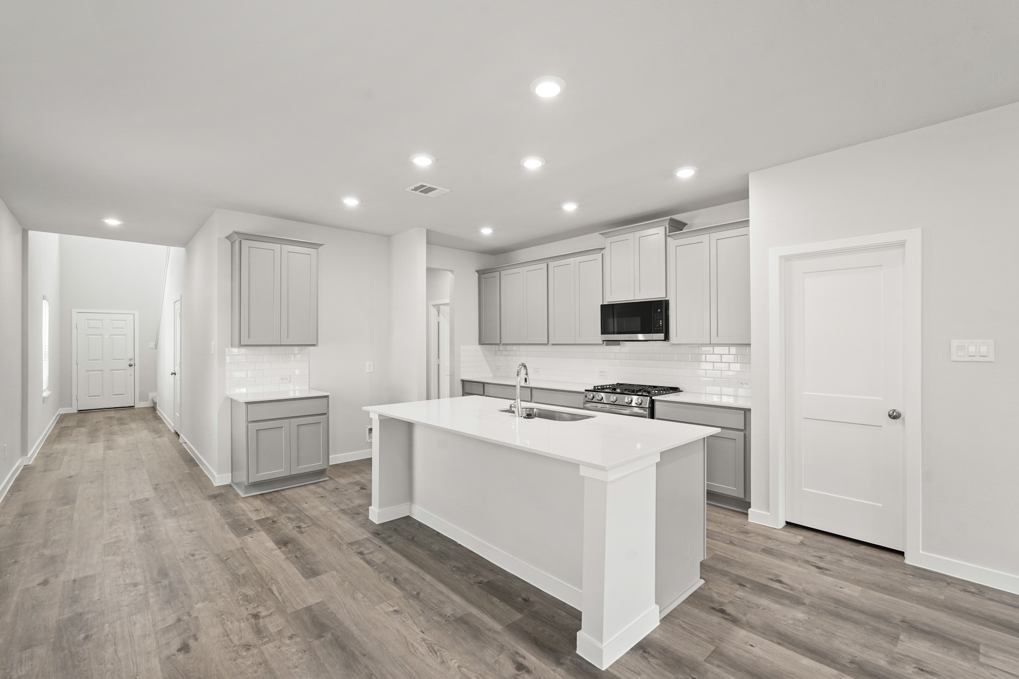 213 Spring Drive Hockley, TX 77447 - Photo 6 of 26 a kitchen with white cabinets and stainless steel appliances
