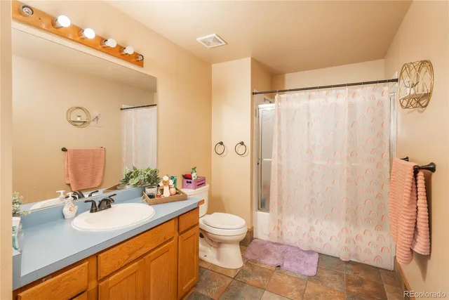 a bathroom with a sink a toilet and shower curtain