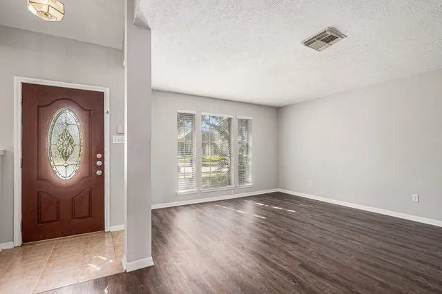 an empty room with wooden floor and a window