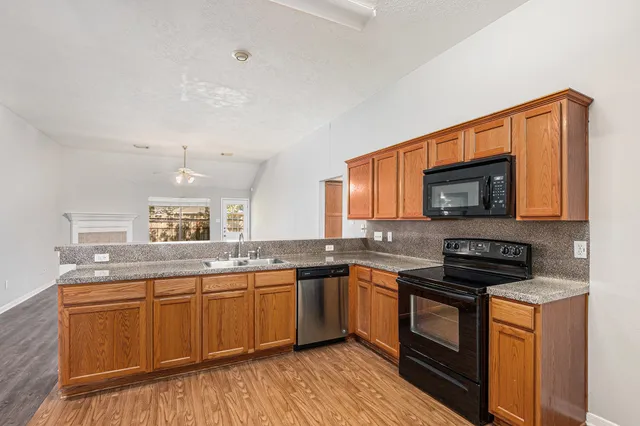 a kitchen with stainless steel appliances granite countertop a sink stove and microwave