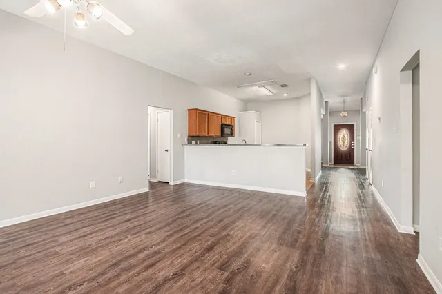 a view of a big room with wooden floor and a kitchen