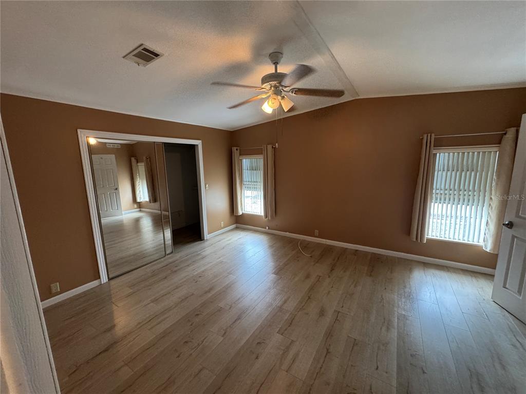 16203 Brookridge Boulevard Brooksville, FL 34613 - Photo 13 of 44 a view of an empty room with wooden floor and a window