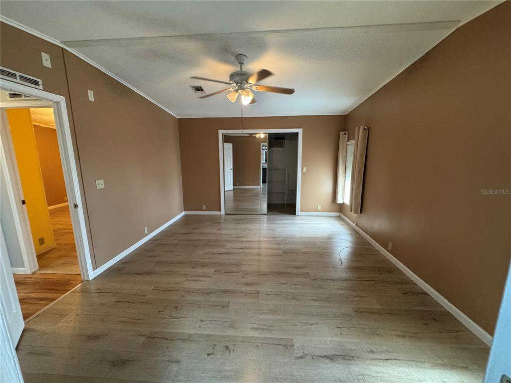 16203 Brookridge Boulevard Brooksville, FL 34613 - Photo 14 of 44 a view of an empty room with wooden floor and a window