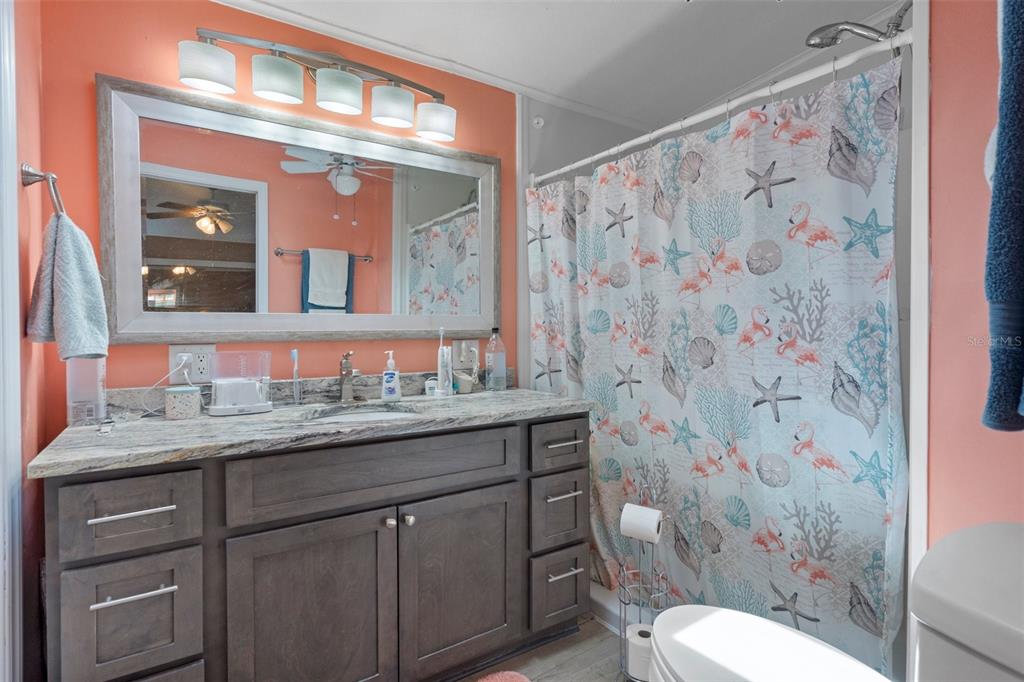 16203 Brookridge Boulevard Brooksville, FL 34613 - Photo 17 of 44 a bathroom with a granite countertop sink a toilet and a mirror