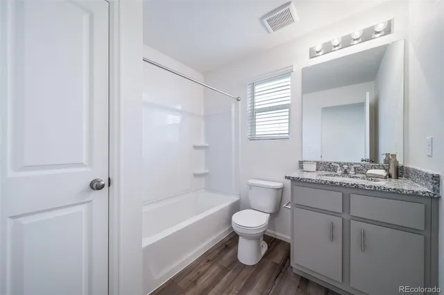 a bathroom with a granite countertop toilet a sink and a bathtub
