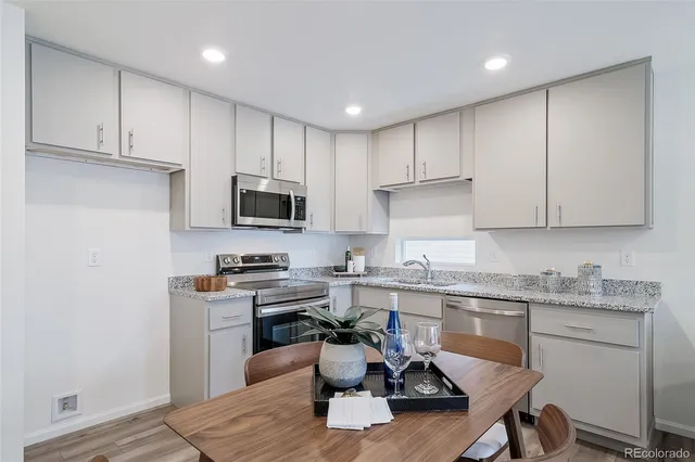 a kitchen with a sink white cabinets and stainless steel appliances