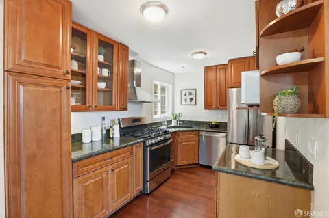 a kitchen with stainless steel appliances granite countertop a stove a sink and a refrigerator