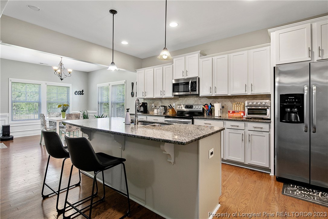 164 Valley Stream Road Spring Lake, NC 28390 - Photo 11 of 49 a kitchen with stainless steel appliances granite countertop a sink a stove a refrigerator cabinets and chairs