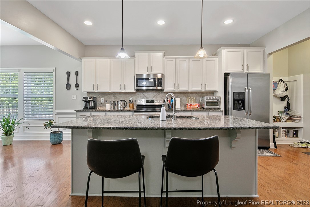 164 Valley Stream Road Spring Lake, NC 28390 - Photo 12 of 49 a kitchen with stainless steel appliances granite countertop a stove top oven a refrigerator a sink and chairs