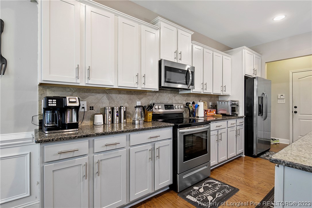 164 Valley Stream Road Spring Lake, NC 28390 - Photo 19 of 49 a kitchen with stainless steel appliances granite countertop a refrigerator sink and white cabinets
